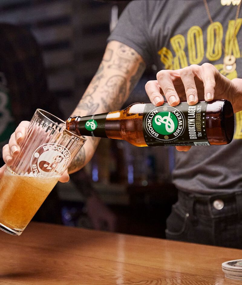 A bottle of Brooklyn Brewery beer being poured into a glass