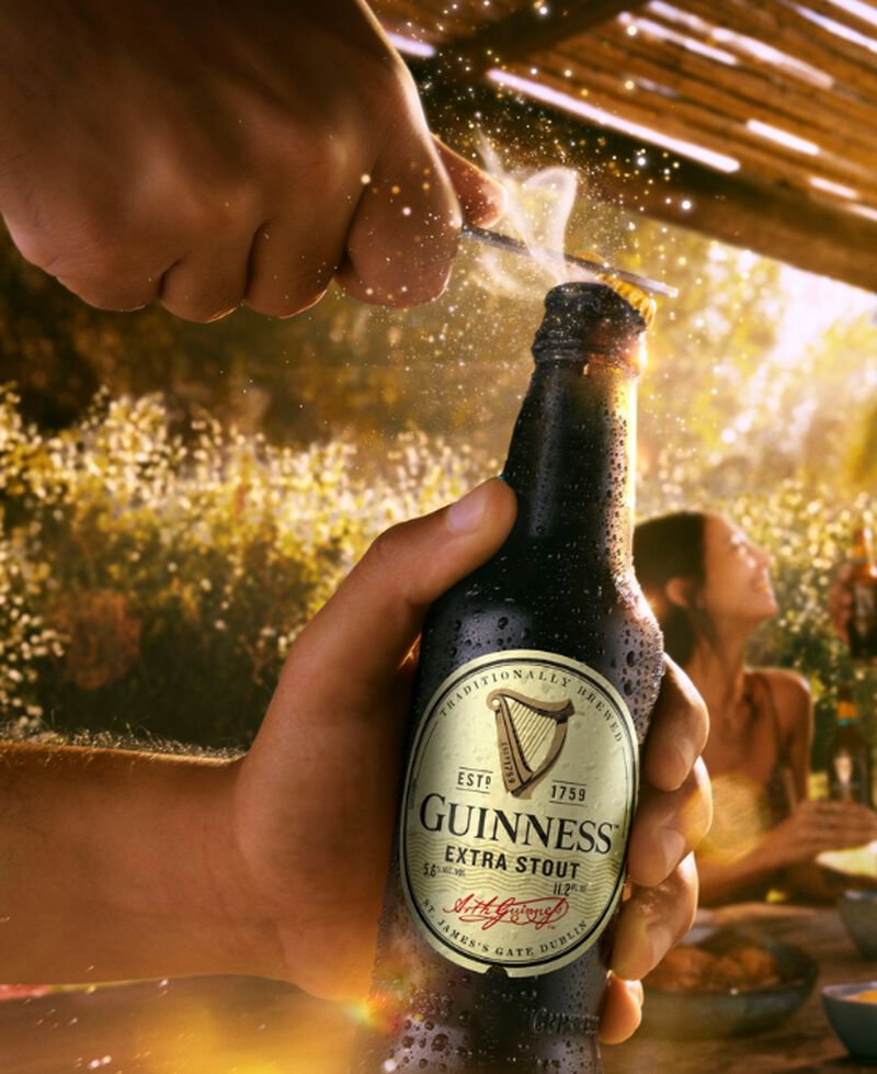 A bottle of Guinness Extra Stout being opened