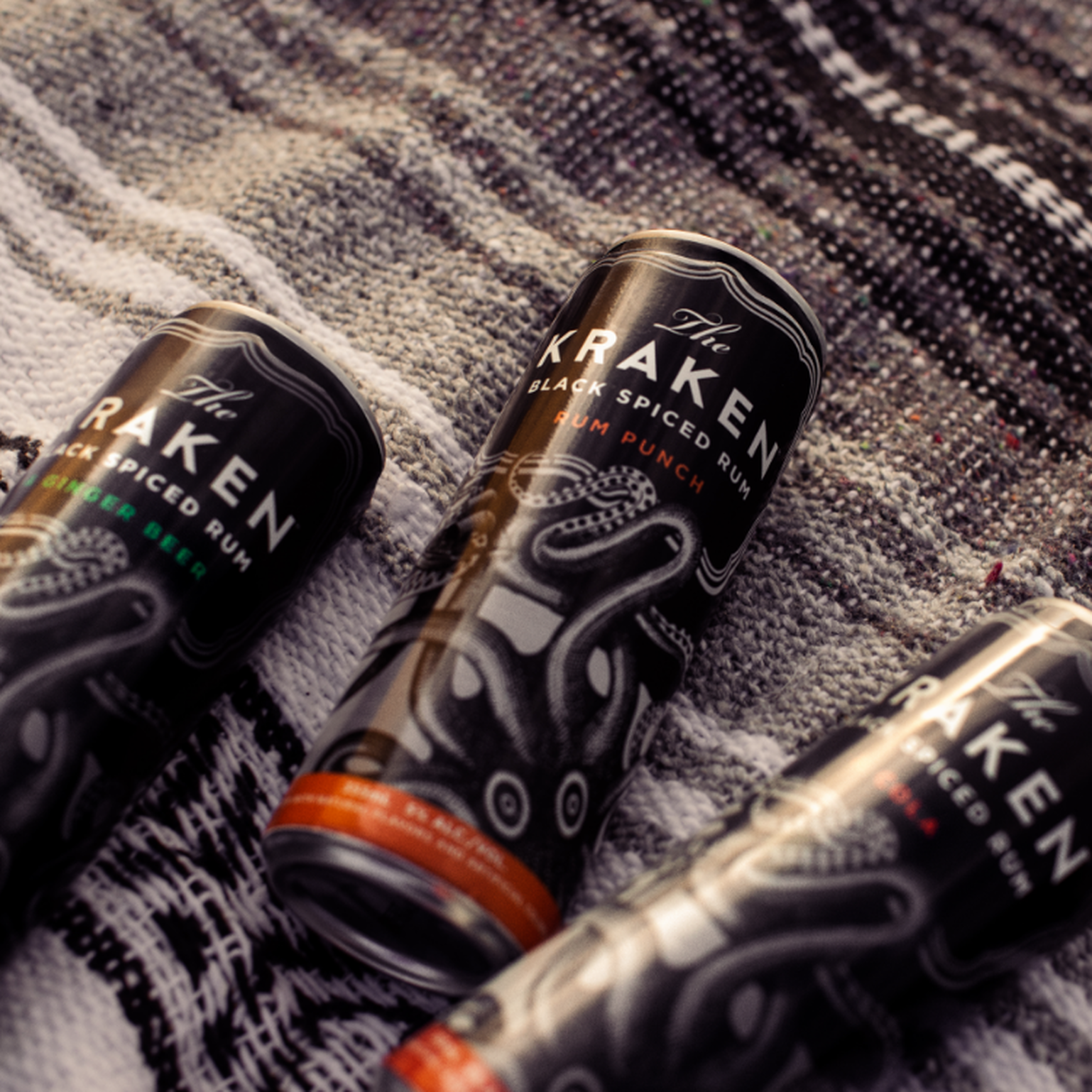 The Kraken Canned Cocktails on a beach blanket