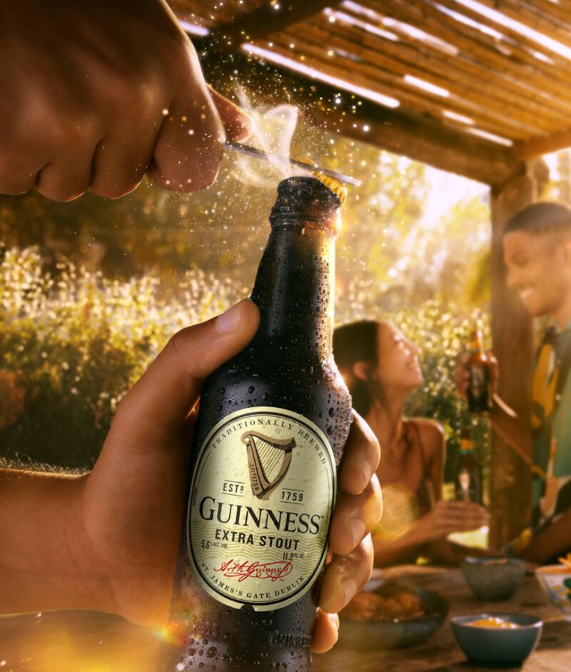 A bottle of Guinness Extra Stout being opened