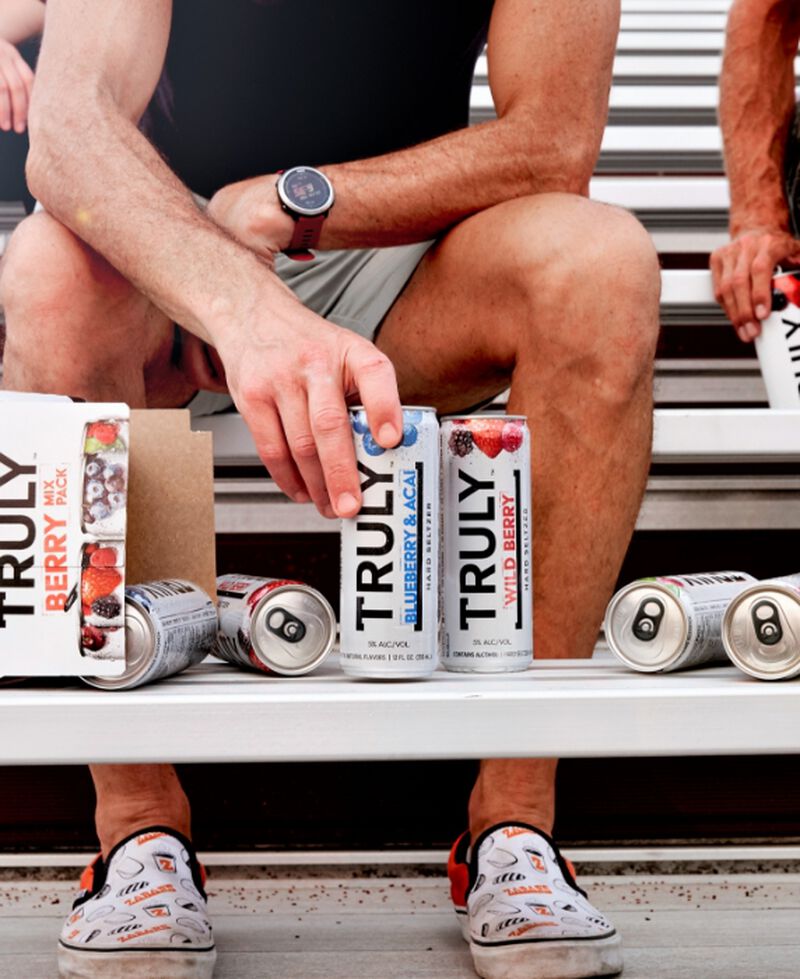Cans from a Truly Hard Seltzer Berry Mix Pack sitting on bleachers