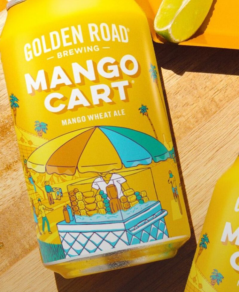 Can of Golden Road Spicy Mango Cart laying on a table with lime