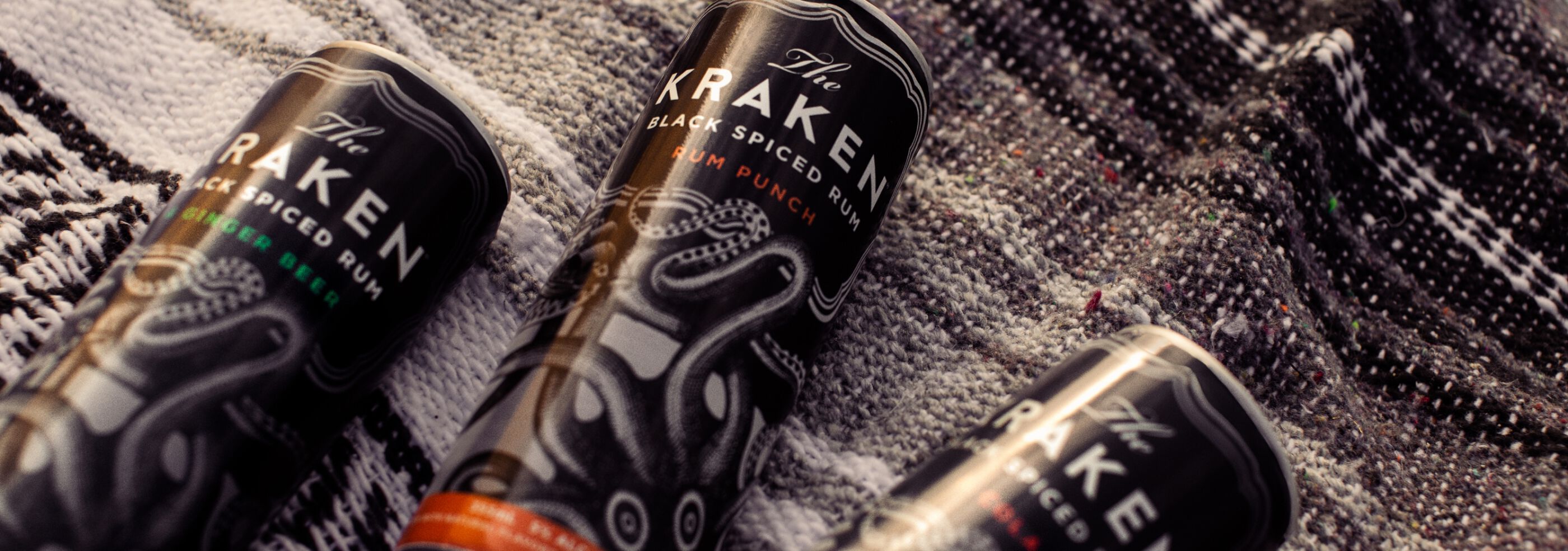 The Kraken Canned Cocktails on a beach blanket